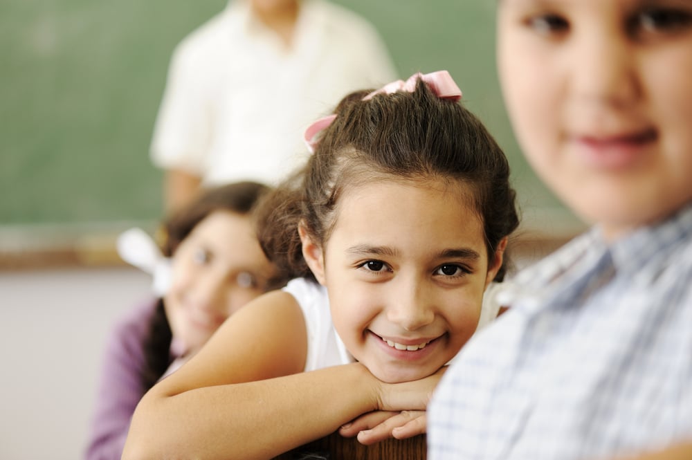 Happy friends and colleagues in classroom, male and female, smiling